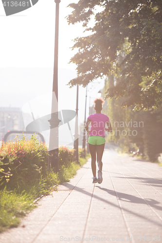 Image of african american woman jogging in the city