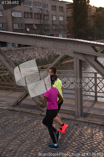Image of young multiethnic couple jogging in the city