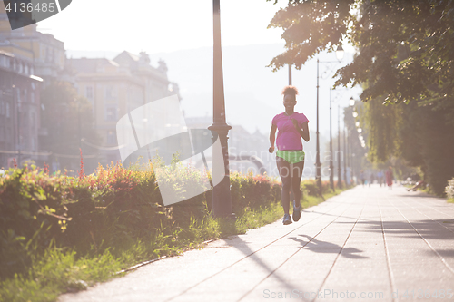 Image of african american woman jogging in the city