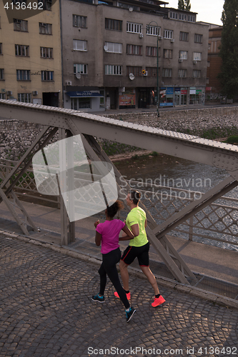 Image of young multiethnic couple jogging in the city