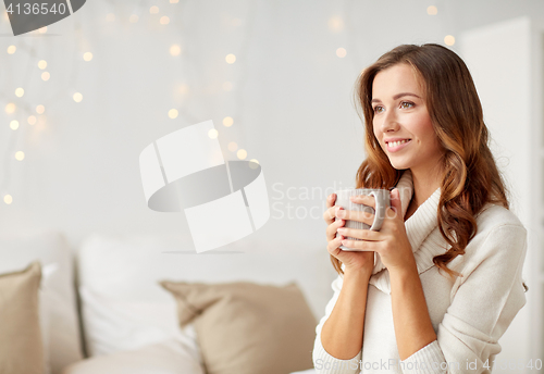 Image of happy woman with cup of tea or coffee at home