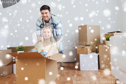 Image of happy couple having fun with boxes at new home