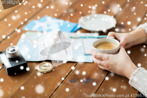 Image of hands with coffee cup and travel stuff