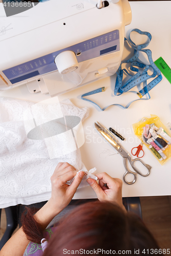 Image of Seamstress with cloth in hand