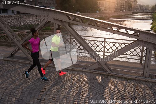 Image of young multiethnic couple jogging in the city