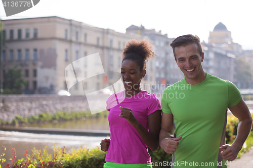 Image of young multiethnic couple jogging in the city