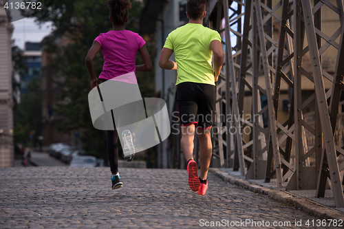Image of multiethnic couple jogging in the city