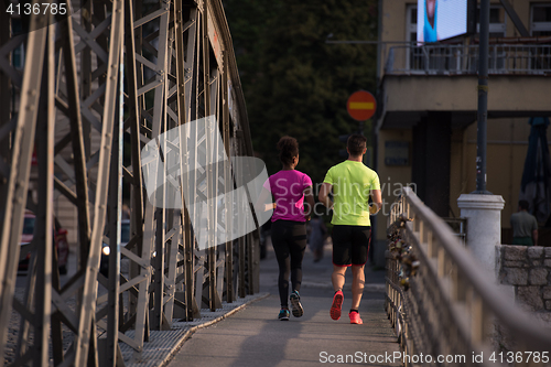 Image of multiethnic couple jogging in the city