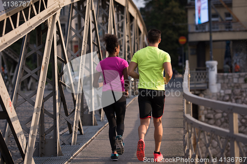 Image of multiethnic couple jogging in the city