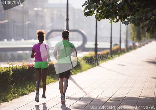 Image of young multiethnic couple jogging in the city