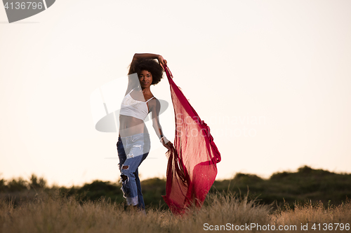 Image of black girl dances outdoors in a meadow