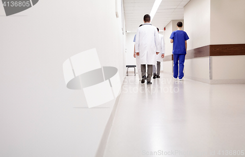 Image of group of medics or doctors walking along hospital