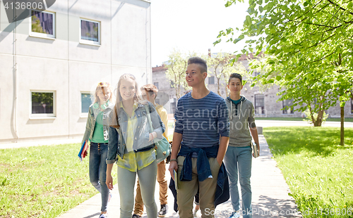 Image of group of happy teenage students walking outdoors