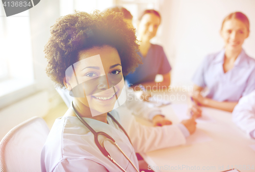 Image of happy doctor over group of medics at hospital