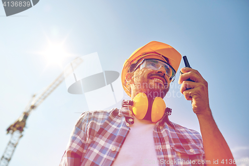 Image of builder in hardhat with walkie talkie