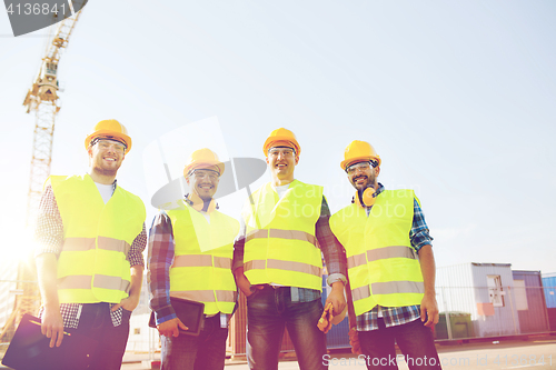 Image of group of smiling builders with tablet pc outdoors