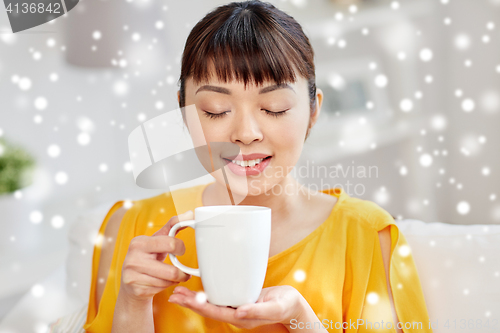 Image of happy asian woman drinking from tea cup