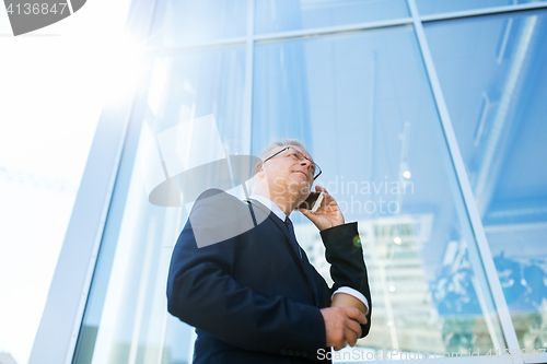 Image of senior businessman calling on smartphone in city