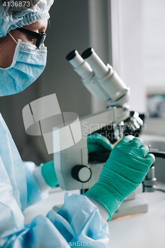 Image of Crop hands putting microscope glasses in box