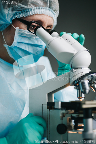 Image of Scientist working in laboratory with microscope