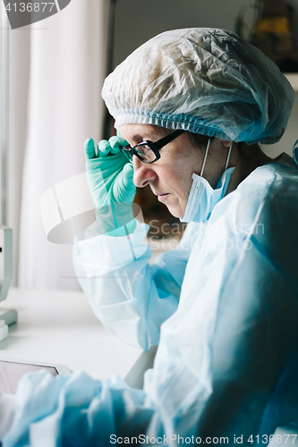 Image of Side view of scientist working on tablet