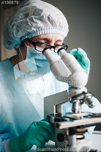 Image of Scientist working in laboratory with microscope