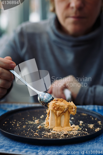 Image of woman breaks off a piece of dessert