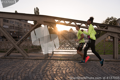 Image of young multiethnic couple jogging in the city
