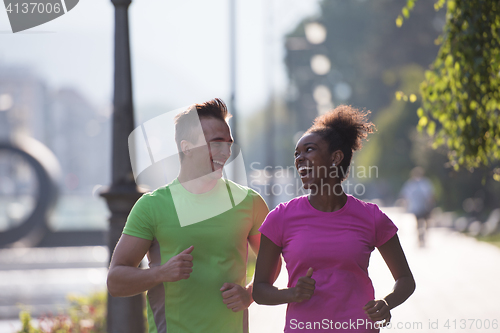 Image of young multiethnic couple jogging in the city