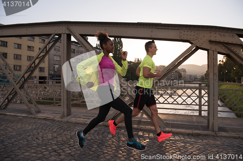 Image of young multiethnic couple jogging in the city