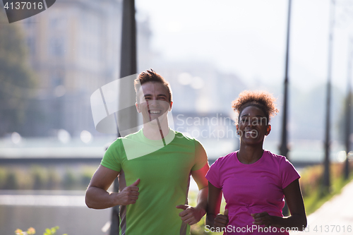 Image of young multiethnic couple jogging in the city