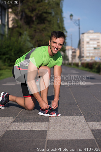 Image of Young athlete, runner tie shoelaces in shoes