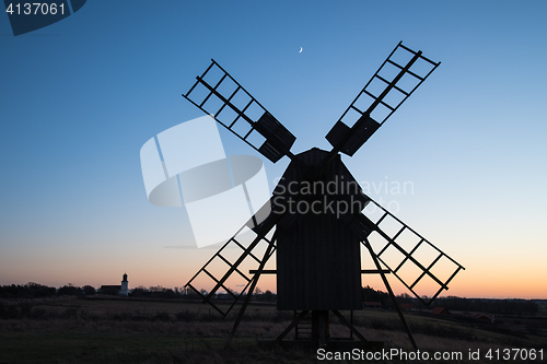 Image of Traditional windmill and a church silhouettes