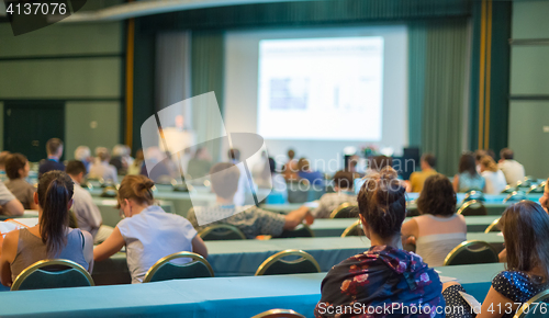 Image of Audience in lecture hall participating at business conference.