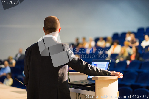 Image of Public speaker giving talk at business event.