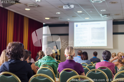 Image of Audience in lecture hall participating at business conference.