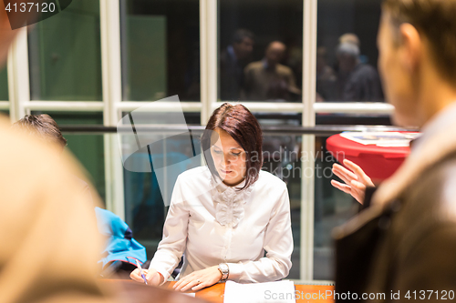 Image of Personal assistant working at registration desk at corporate event.