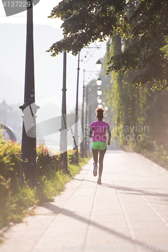 Image of african american woman jogging in the city