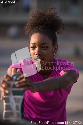 Image of African American woman doing warming up and stretching
