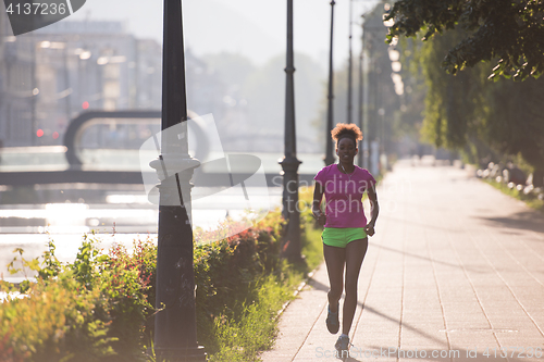 Image of african american woman jogging in the city