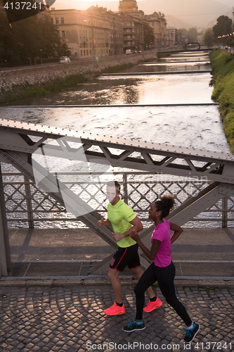 Image of young multiethnic couple jogging in the city