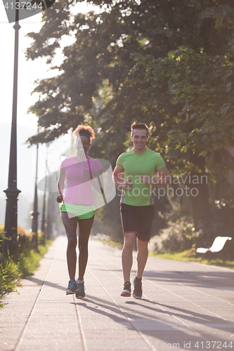 Image of young multiethnic couple jogging in the city