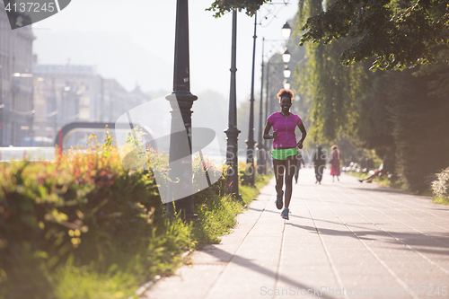 Image of african american woman jogging in the city