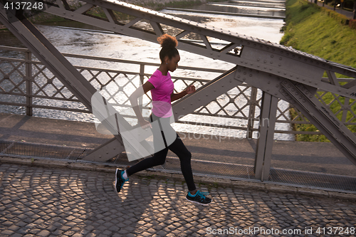 Image of african american woman running across the bridge