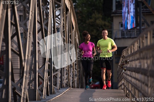Image of multiethnic couple jogging in the city