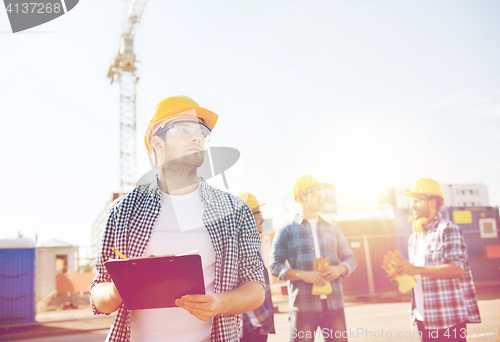 Image of group of builders in hardhats outdoors