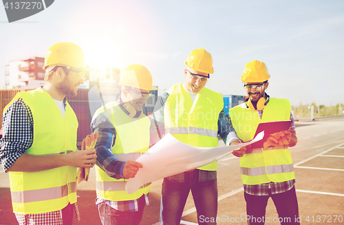 Image of group of builders with tablet pc and blueprint