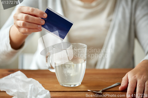 Image of woman pouring medication into cup of water