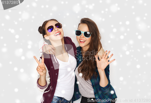 Image of smiling teenage girls in sunglasses showing peace