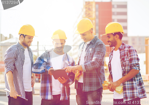 Image of group of smiling builders with tablet pc outdoors